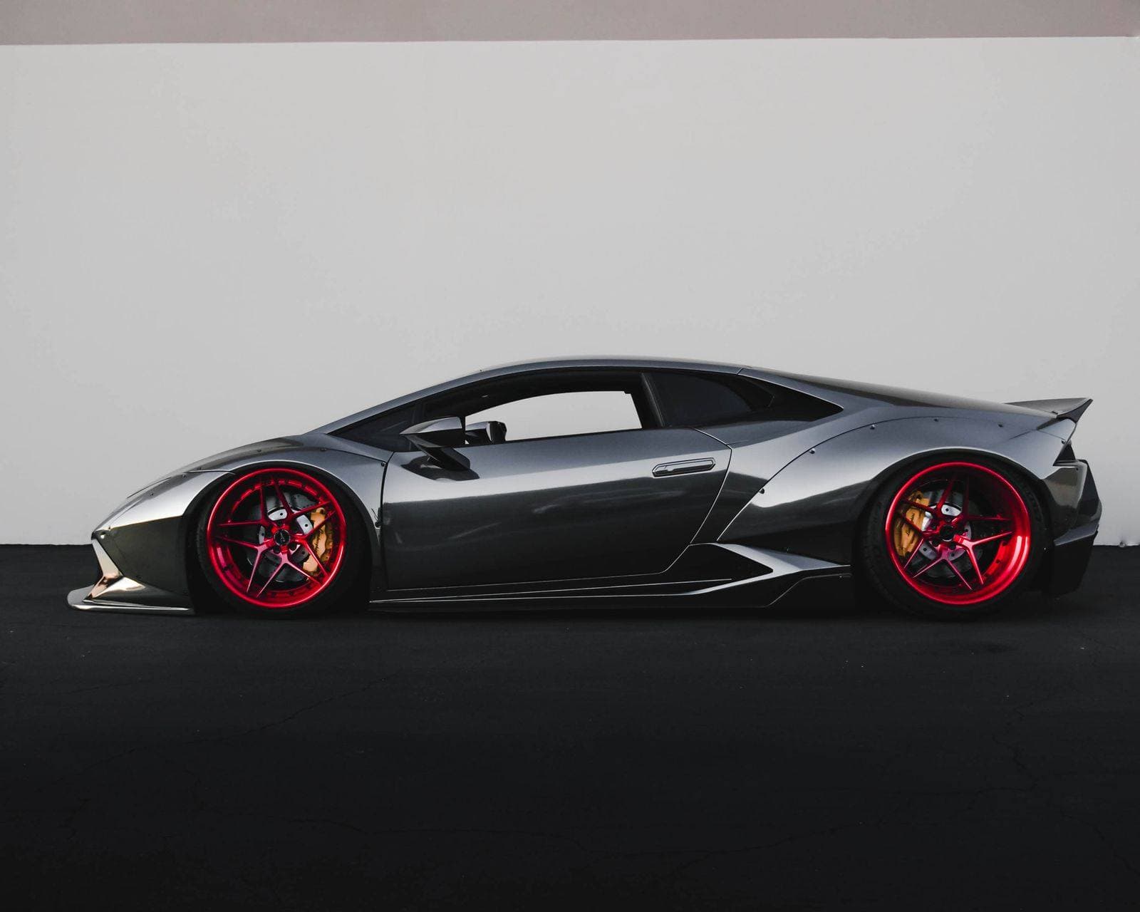 Grey sports coupe with red wheels against a plain wall, used as the automotive concept preview.