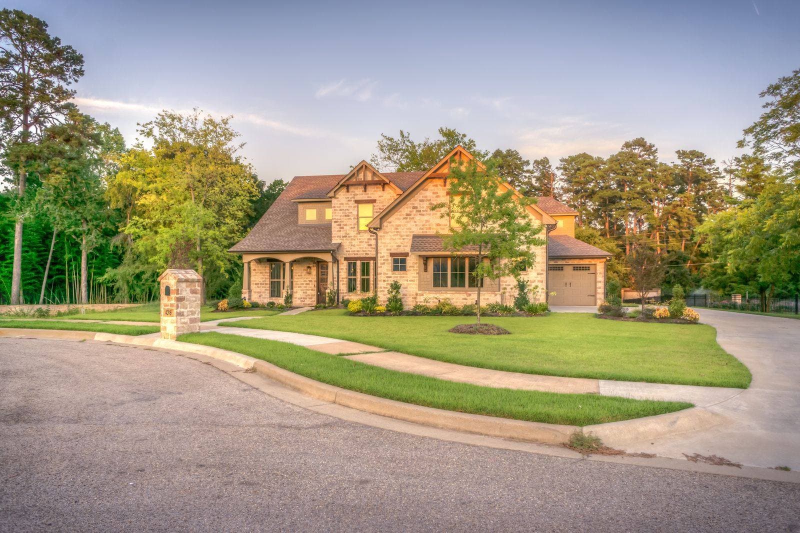 Stone-clad house with a lawn and concrete driveway, used as the home-services concept preview.